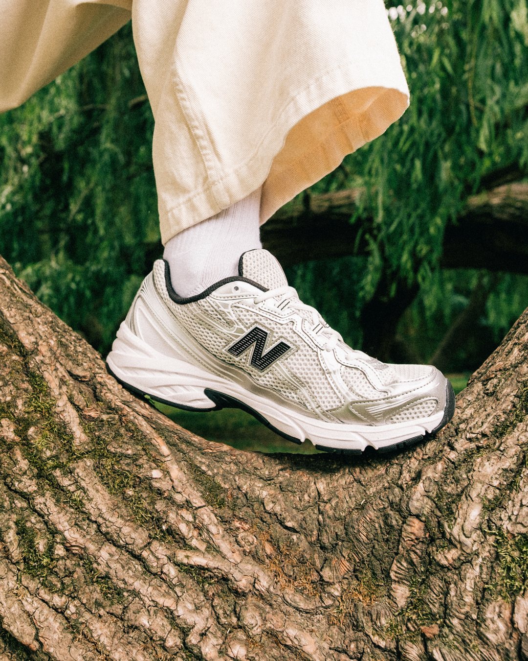 Person wearing silver New Balance 740s in the outdoors.