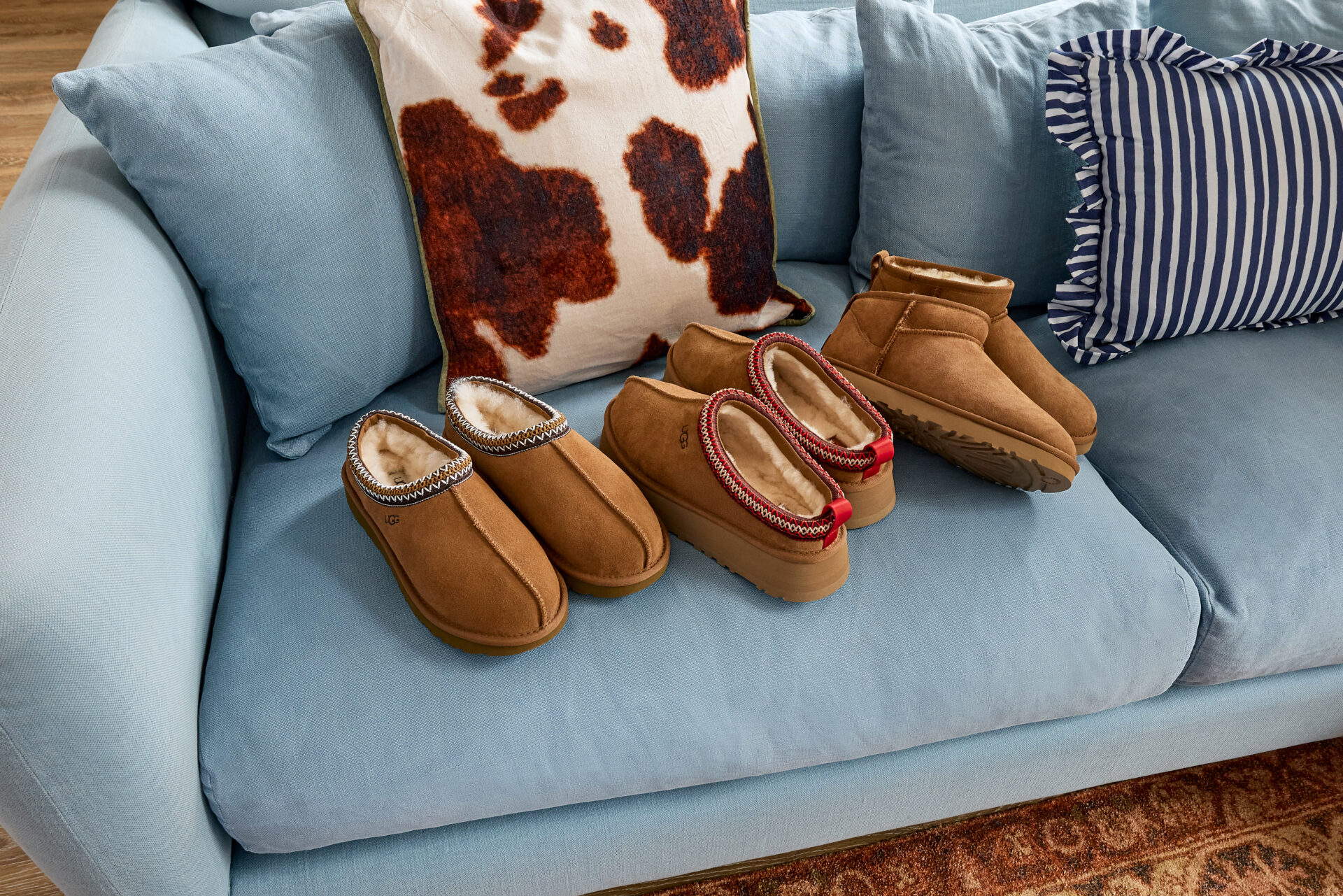 Three pairs of UGGs on a couch.