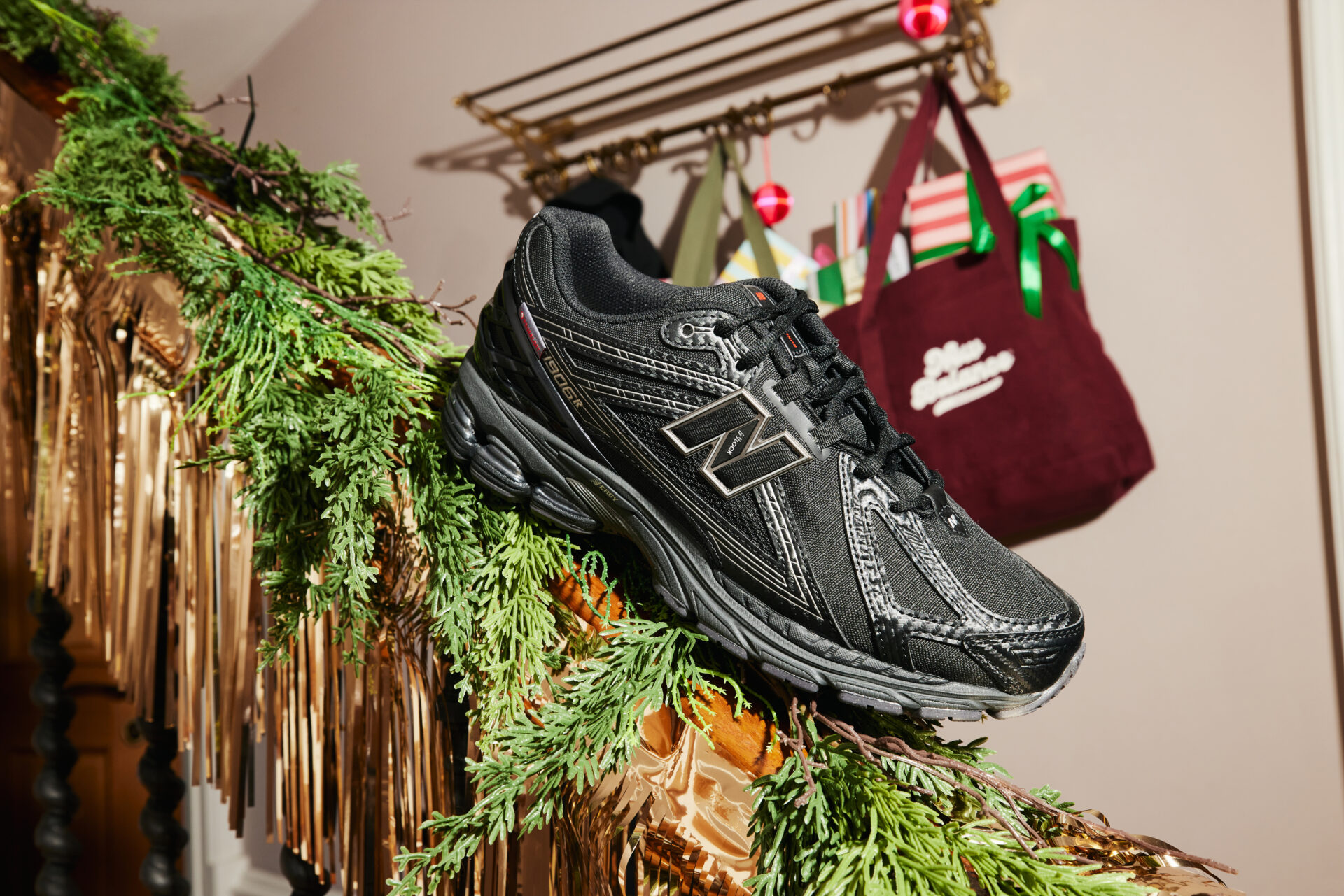 A black New Balance 1906R sitting on a festively decorated banister.