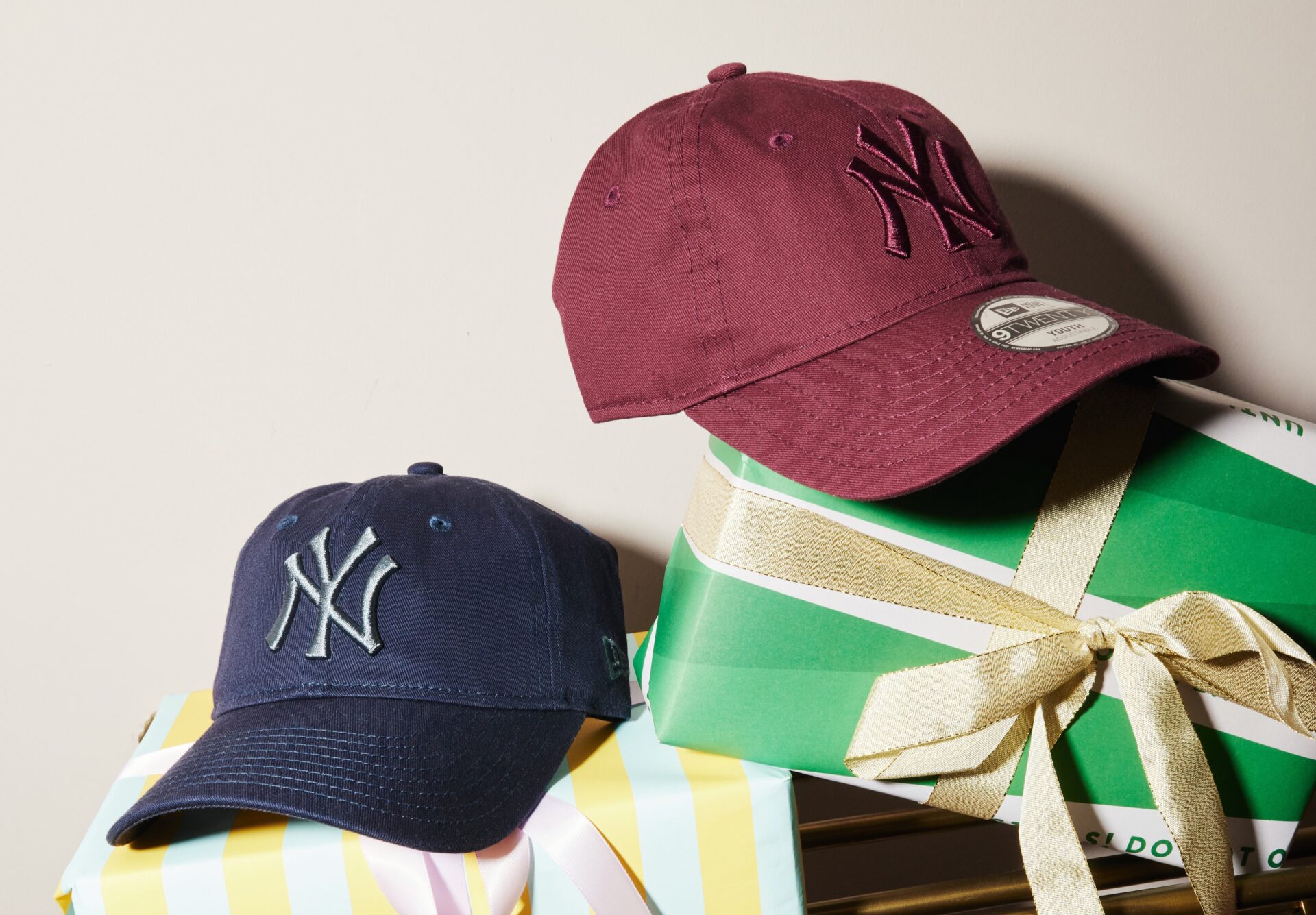A pair of burgundy and blue Yankees caps.