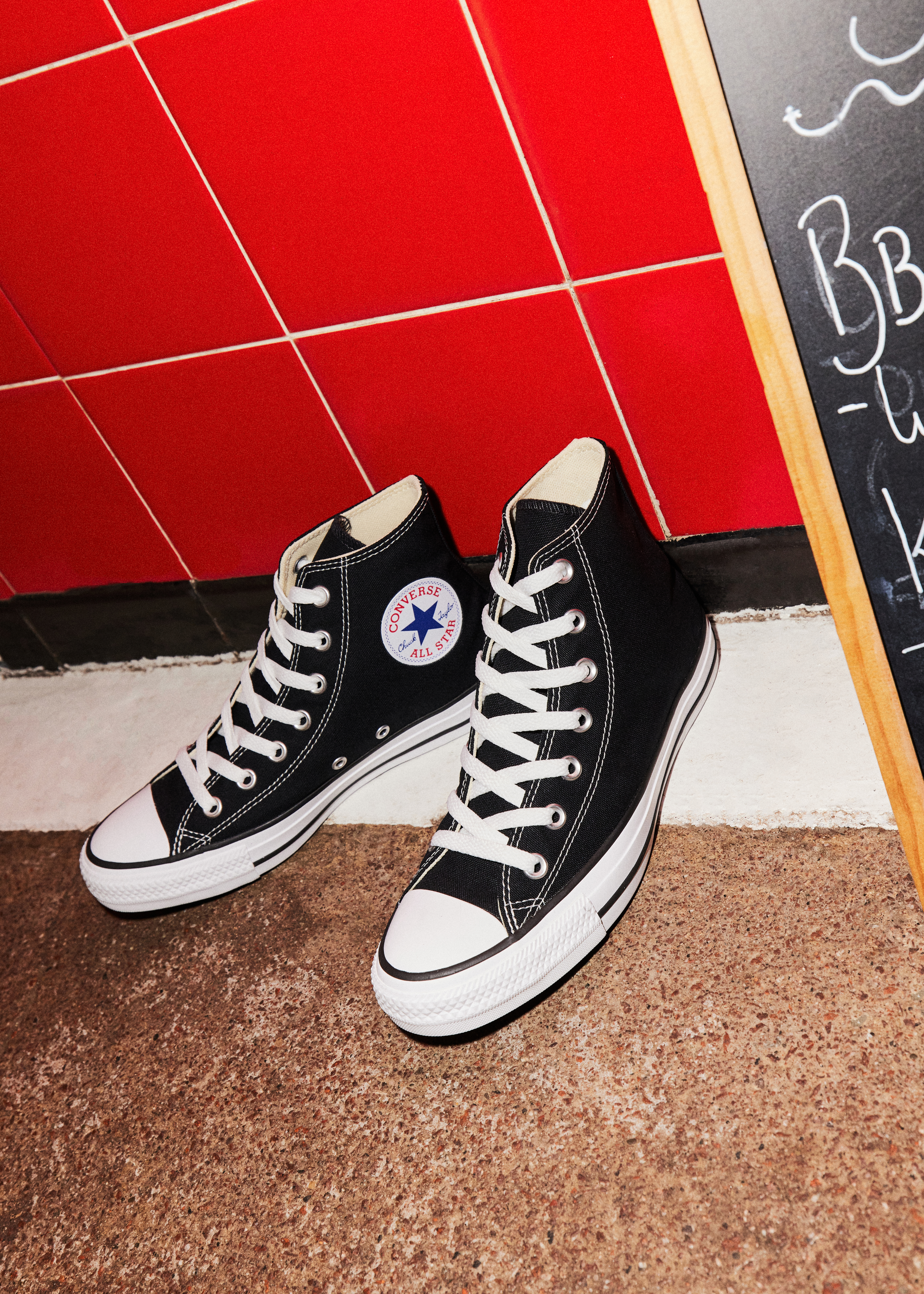 A pair of black and white Converse All Star Hi trainers.
