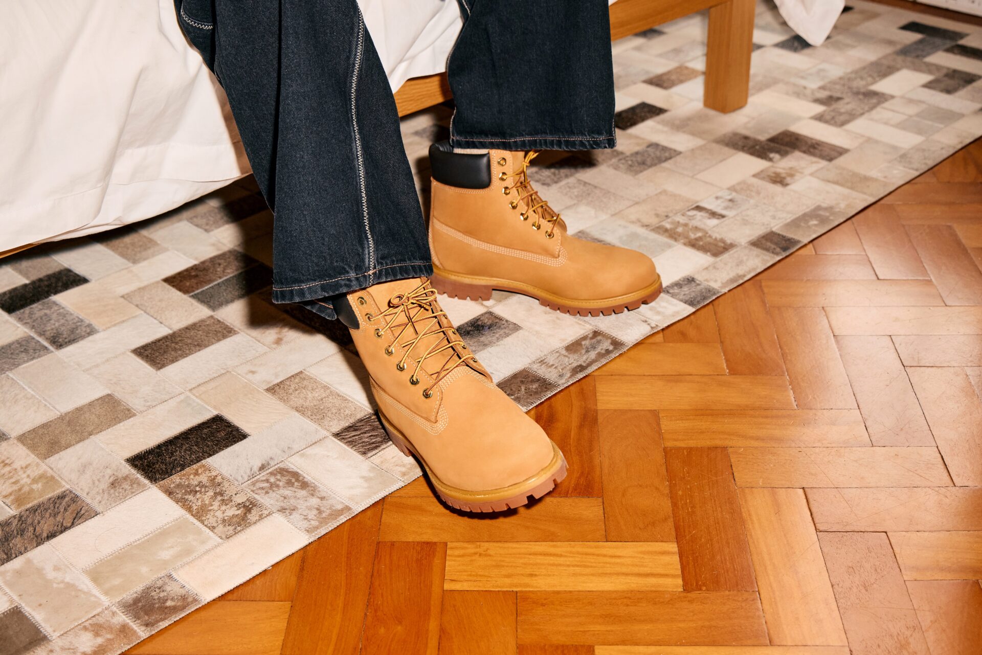 Person wearing brown Timberland boots with dark blue jeans.