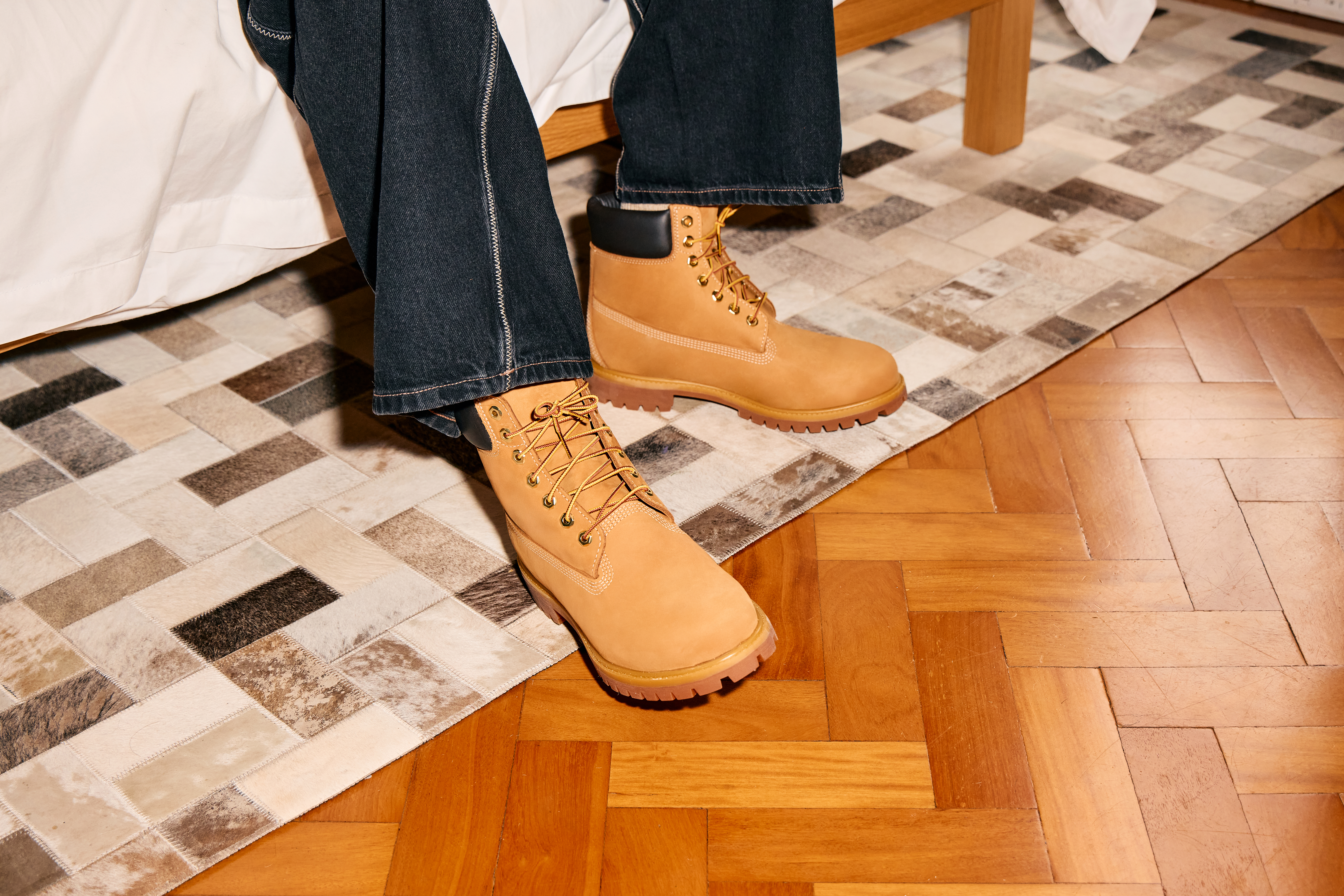 Person wearing brown Timberland boots with dark blue jeans.