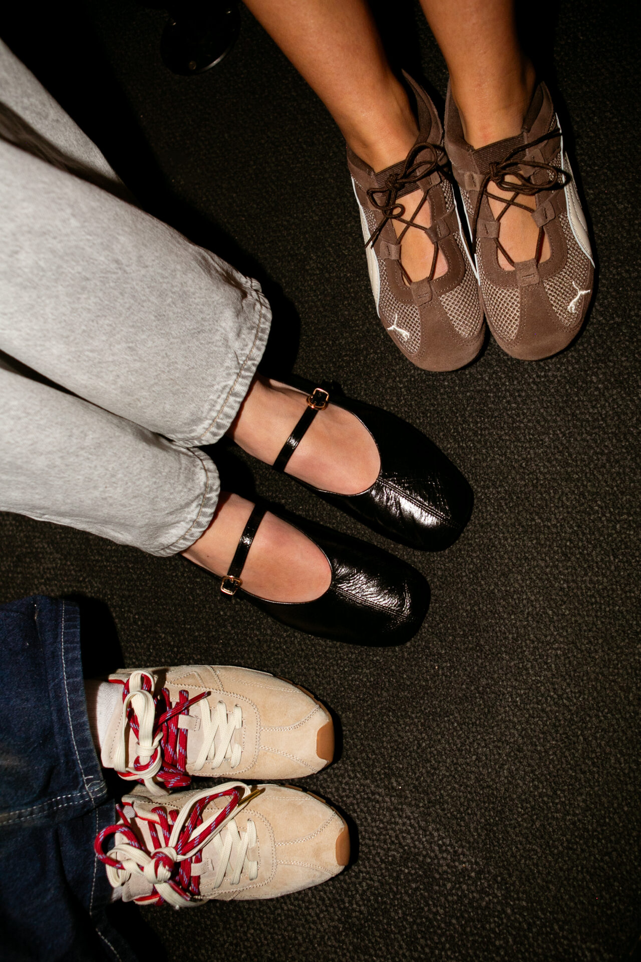 One person wearing the PUMA Speedcat Go in Brown, one wearing the schuh London Leather Ballet in Black with light grey jeans, and one wearing the victoria Aster Serraje in Beige with a dark wash denim skirt.