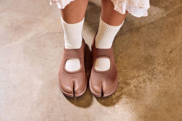 Person wearing TABI trainer in brown with white socks.