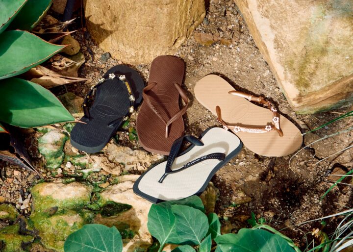 Four different Havaianas flip flops in neutral colourways, sitting outside.