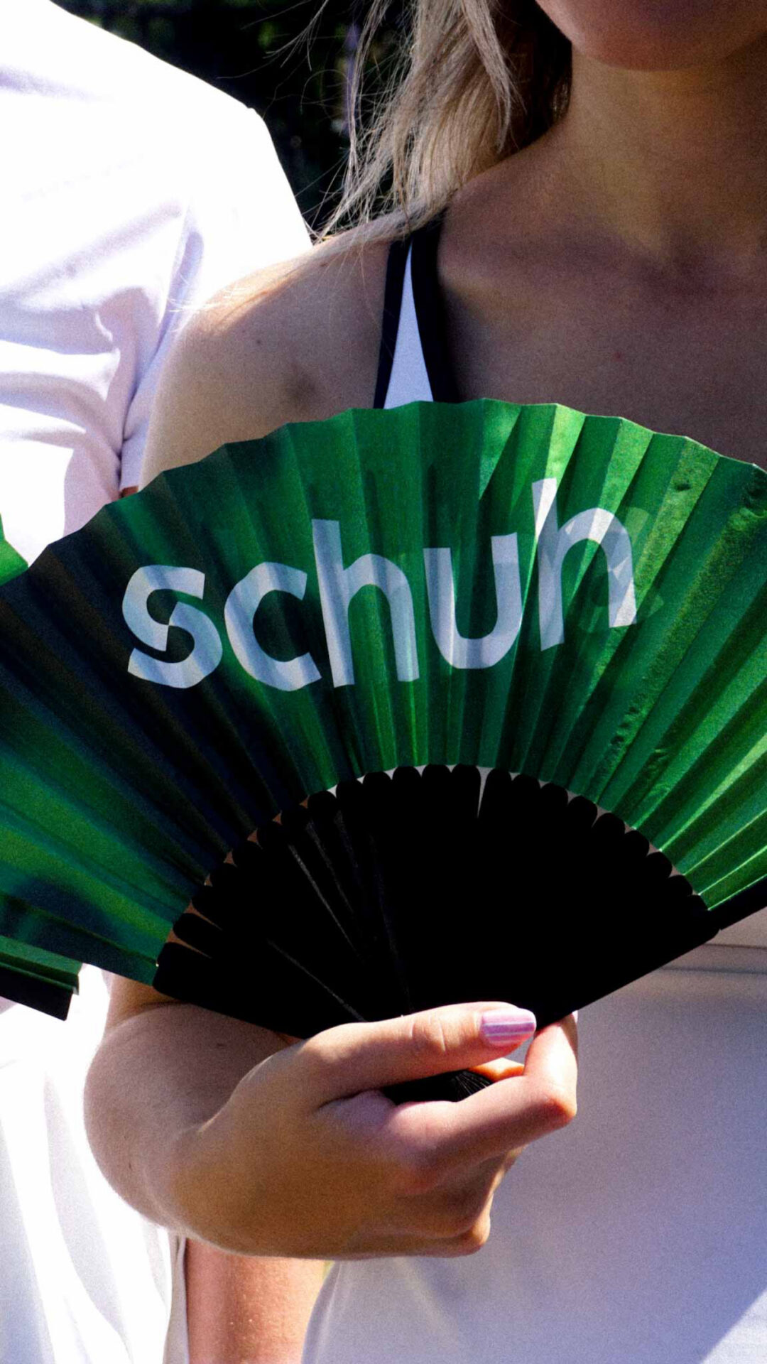 Person holding schuh branded fan.